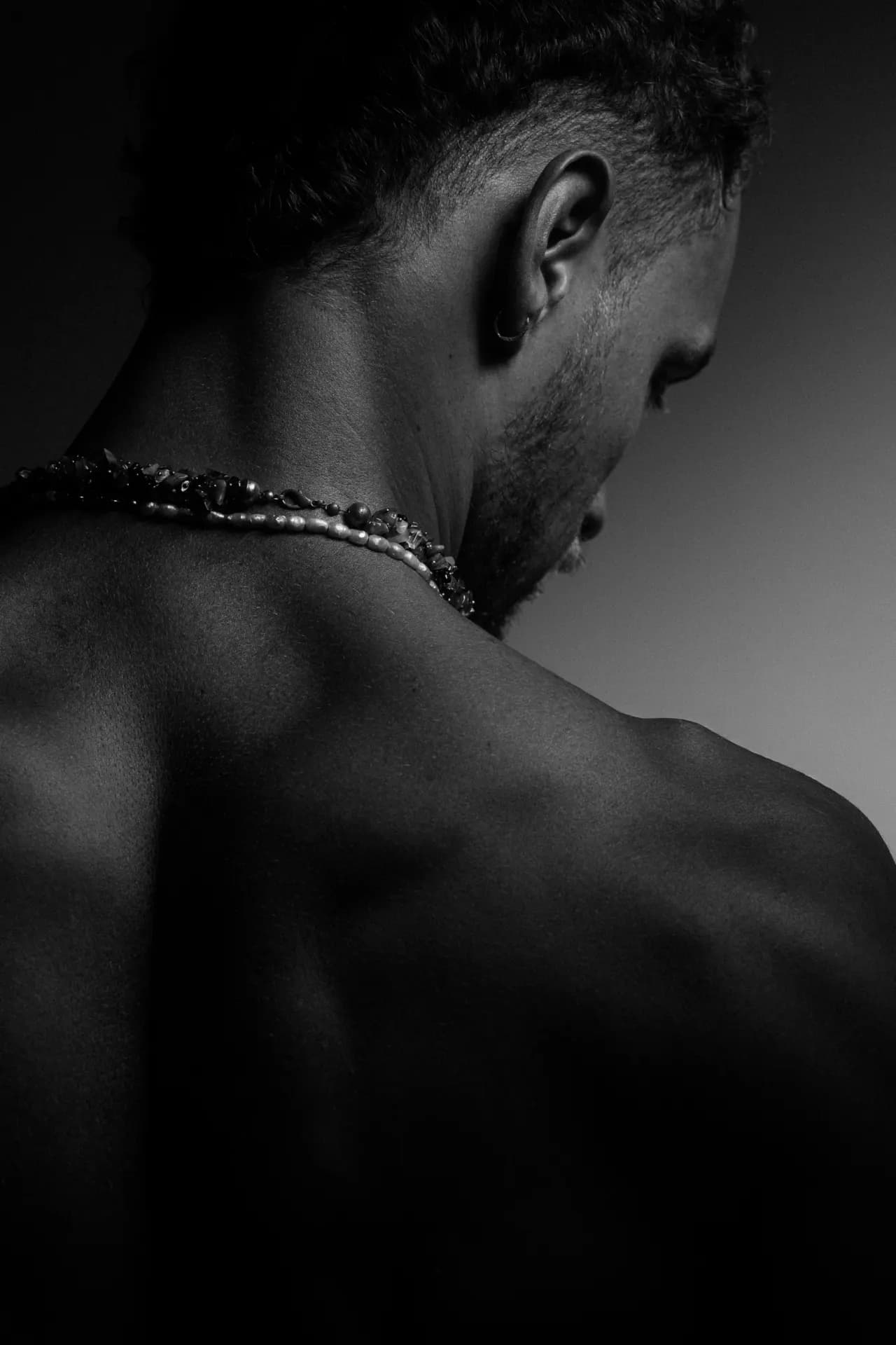 Coach Luki looking over his shoulder, back and shoulder muscles defined — book a personal training session in Berlin